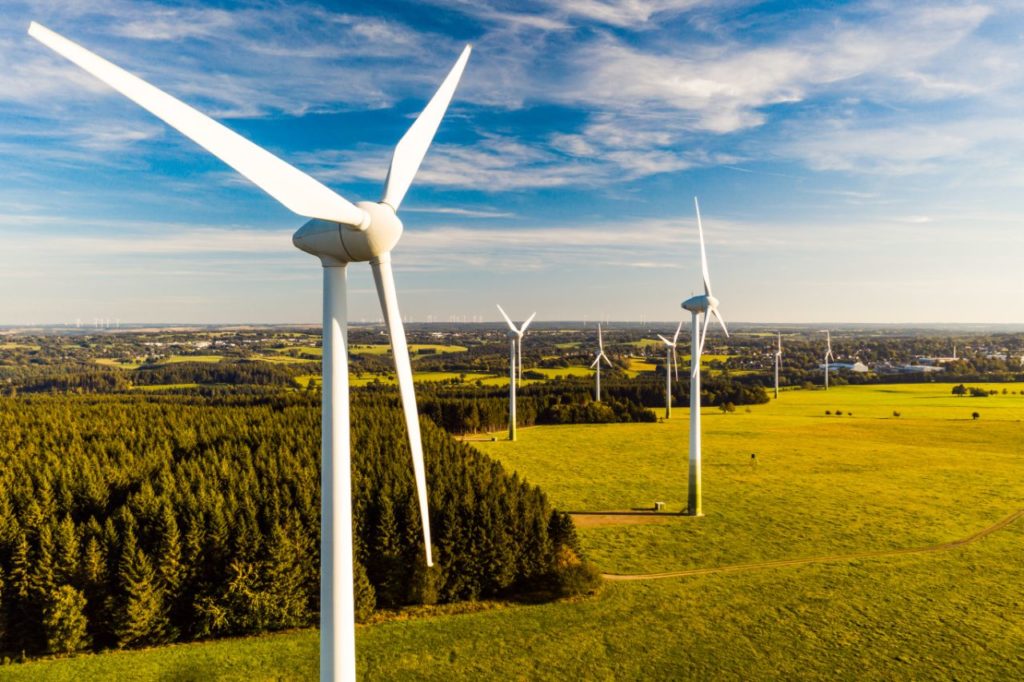 Wind energy turbines in a green field